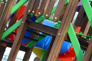 Fragment eines Spielplatzes aus Kunststoff und Holz, in verschiedenen Farben bemalt foto
