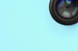 Kameraobjektiv mit geschlossener Blende liegen auf Texturhintergrund aus modepastellblauem Farbpapier foto