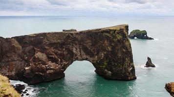 Steinbogen auf der Halbinsel Dyrholaey in Island anzeigen foto