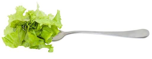 Gabel mit aufgespießtem frischem grünem Salat isoliert foto