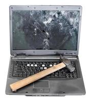 Vorderansicht kaputter Laptop mit Hammer auf der Tastatur foto