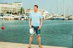Modeporträt des gutaussehenden Mannes am Pier gegen Yachten foto