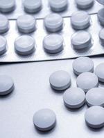 weiße medizinische pillen sind auf dem grauen tisch verteilt. foto