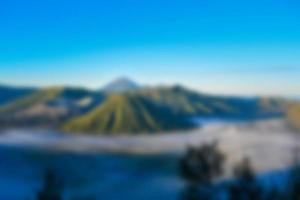 verschwommene Sicht auf den Bromo bei Sonnenaufgang. Berghintergrund und Naturlandschaft verwischen foto