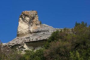 alte höhlenstadt, baqla, ansicht von außen. Felsen in Form des Kopfes einer Schlangenkobra. Sphinx-Kopf foto