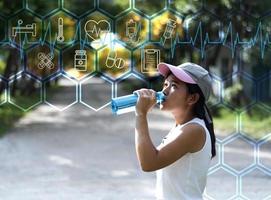asiatische junge frau trinkwasser nach dem joggen, gesund und sportkonzept. foto
