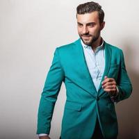 eleganter junger gutaussehender Mann in stilvoller türkisfarbener Jacke.