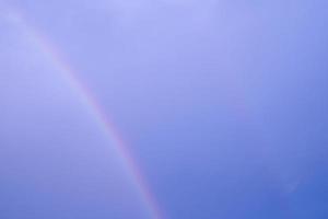 Kurve mehrfarbiger doppelter Regenbogen auf blauem Himmel. abstraktes pastelllicht auf hoher luft auf klima nach regenfall. foto