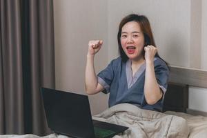 Aufgeregte asiatische Frau, die sich euphorisch fühlt und das Ergebnis des Online-Gewinns feiert, junge Frau, die sich über gute E-Mail-Nachrichten freut, motiviert durch ein großartiges Angebot oder eine neue Gelegenheit, hat einen Job bekommen foto