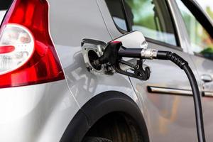 graues metallisches Auto, das an der Tankstelle tankt - Nahaufnahme mit selektivem Fokus foto