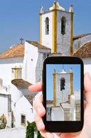 tourist, der foto von weißen häusern in der algarve macht