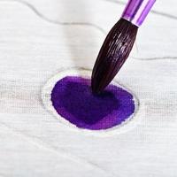 Malen von violetten Ornamenten auf Seidenleinwand foto