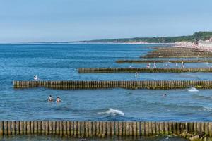 Strand mit hölzernem Wellenbrecher. schöne Meereslandschaft. Urlauber vor Witterungseinflüssen und Küstendrift schützen. foto