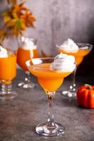 Kürbis-Herbst-Cocktail-Cocktail-Latte mit Gewürzen und Schlagsahne zum Erntedankfest oder Halloween-Party festlich feiern. herbstliche Dekoration foto