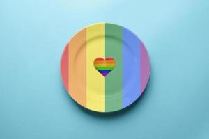 Platte in den Farben der LGBT-Flagge. Pride-Flag-Konzept. romantisches lgbt-festfest. Verabredung mit einsamen Lesben, Schwulen, Bisexuellen oder Transgendern im Café.