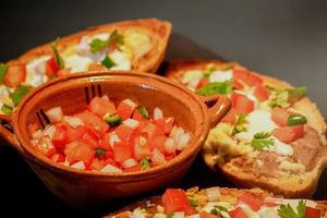 mexikanische molletes, traditionelles essen mit brot, bohnen, käse, tomate und chili foto