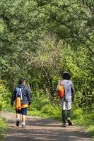 Zwei junge Männer und Freunde steigen in die Schlucht, Vegetation und Bäume, Huentitan-Schlucht, Guadalajara, Mexiko foto