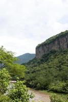 dreckiger fluss, gesehen durch die huentitan-schlucht in guadalajara, grüne vegetation, bäume, pflanzen und berge, mexiko foto