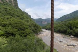 rostiges kabel, fluss und berg im hintergrund, vegetation barranca huentitan, guadalajara foto
