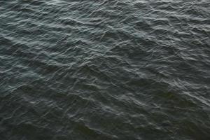 abstrakter hintergrund des flusswasserflusses unter dem einfluss von licht. die Beschaffenheit des Wassers foto