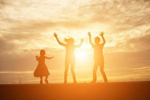 Kindersilhouette, Momente der Freude des Kindes. auf dem natursonnenuntergang foto