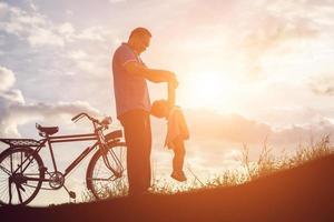 Vater und Sohn haben Spaß am Sonnenuntergang foto