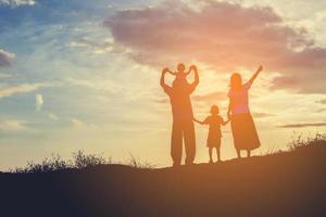 glückliche familie, die auf der straße in der sonnenuntergangszeit tanzt. Abendparty in der Natur foto