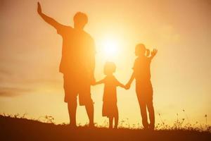 Silhouette einer glücklichen Familie und glücklicher Sonnenuntergang foto