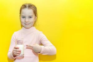 kleines Mädchen Mädchen hält ein Glas Milch foto