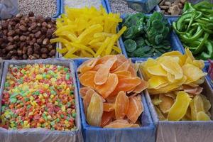 getrocknete früchte melone, ananas, mango, kiwi, datteln, pampelmuse, getrocknete früchte, haufen kandierte scheiben in schachteln auf dem markt foto