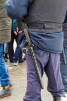 russischer polizist mit schwarzem gummi-tonfa-schlagstock, der aus der uniform herausragt foto