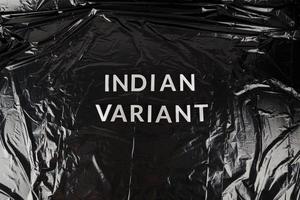 worte indische variante mit silbernen metallbuchstaben auf zerknittertem schwarzem plastiktütenhintergrund foto