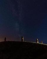 Vier steinerne Köpfe auf einem Hügel in der Nacht