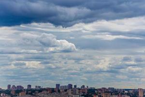 russisches Sommertageslicht-Stadtbild mit großen Kumuluswolken und winziger Horizontlinie der Platteneigentumshäuser foto