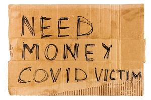 Worte brauchen Geld Covid-Opfer handschriftlich auf rechteckigem Flachkarton - Obdachlosenplakat, isoliert auf weißem Hintergrund foto