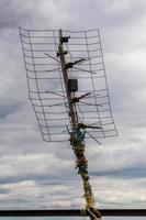 Hässliche alte Fernsehantenne im Freien auf bewölktem Himmelshintergrund foto