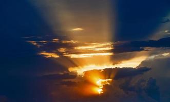 bewölkter sonnenunterganghimmel mit gelben sonnenstrahlen ohne horizont foto