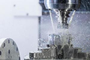 Industrielles Nassfräsen in 5-Achsen-CNC-Maschine mit Kühlmittelfluss unter Druck foto