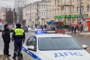 tula, russland 23. januar 2021 russische straßenpolizisten stehen in der nähe eines streifenwagens auf der winterstraße - nahaufnahme mit selektivem fokus auf dachlampe. foto