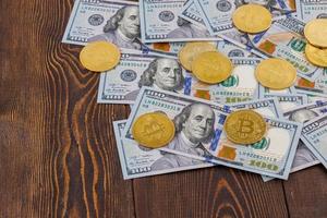 bitcoin-münzen verstreut über us-dollar-papierbanknoten auf holzhintergrund foto