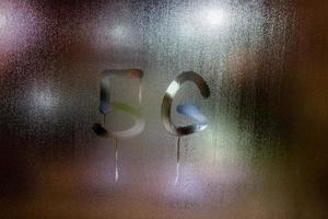 ein handgeschriebenes Wort 5g auf nassem Glas mit verschwommenen Nachtlichtern im Hintergrund foto