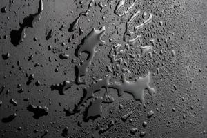 abstrakter hintergrund der nassen schwarzen hydrophoben oberfläche - nahaufnahme mit selektivem fokus foto