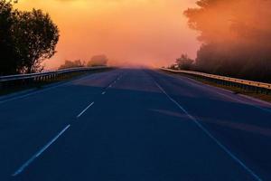 Dichter Nebel am frühen Morgen in Wold an der Sommerautobahn in der Nähe des Flusses mit Leitplanken foto