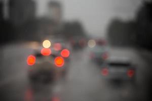 Defokussiertes Bild des Straßenautoverkehrs am Abend nach Regen - Blick von der Straße. foto