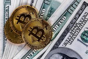 Drei Bitcoin-Shiner über US-Dollar-Banknoten, Nahaufnahmehintergrund foto