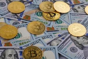 gelbe bitcoin-münzen, die über us-dollar-papierbanknoten verstreut sind foto