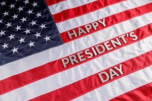 Worte "Happy Presidents Day" mit echten Buchstaben auf der Oberfläche der US-Flagge foto