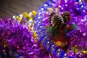 weihnachtsferien-nahaufnahmezusammensetzung mit rotem spielzeugkegel in farbigem lametta-haufen mit selektivem fokus foto