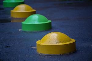 Bunte Hemisphärenpoller zur Verhinderung von Parkplätzen auf der Straße, Nahaufnahme mit selektivem Fokus und Unschärfe foto