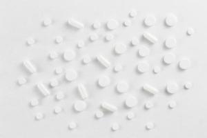 flacher Hintergrund der Pillen, Tabletten, die auf einem Weiß verteilt sind - Ansicht von oben foto
